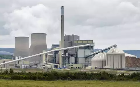 Fotorealistische Ansicht eines Biomasse-Kraftwerks von Drax Group plc, ISIN GB00B1VNSX38, mit Kühltürmen und Lagersilos - Foto: THN