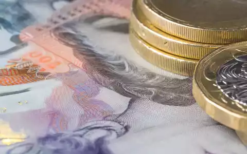 Makroaufnahme von Banknoten und Münzen visualisiert Finanzgeschäft von Close Brothers Group plc, ISIN GB0007668071 - Foto: THN