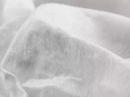 Kimberly-Clark (US4943681035) Makroaufnahme zeigt feine Zellulosefasern von weichem, gefaltetem Tissue-Papier im weichen Licht - Foto: THN