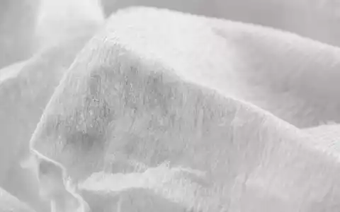 Kimberly-Clark (US4943681035) Makroaufnahme zeigt feine Zellulosefasern von weichem, gefaltetem Tissue-Papier im weichen Licht - Foto: THN