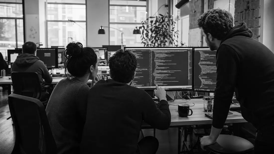 Schwarzweißes Dokumentarfoto von Softwareentwicklern bei nächtlicher Teamarbeit im Büro