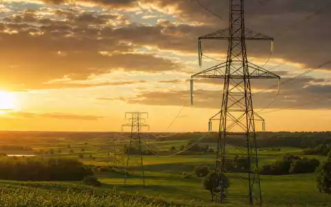 Ameren Corp. US0236081024 photorealistic transmission towers across Missouri farmland at golden hour - Foto: THN