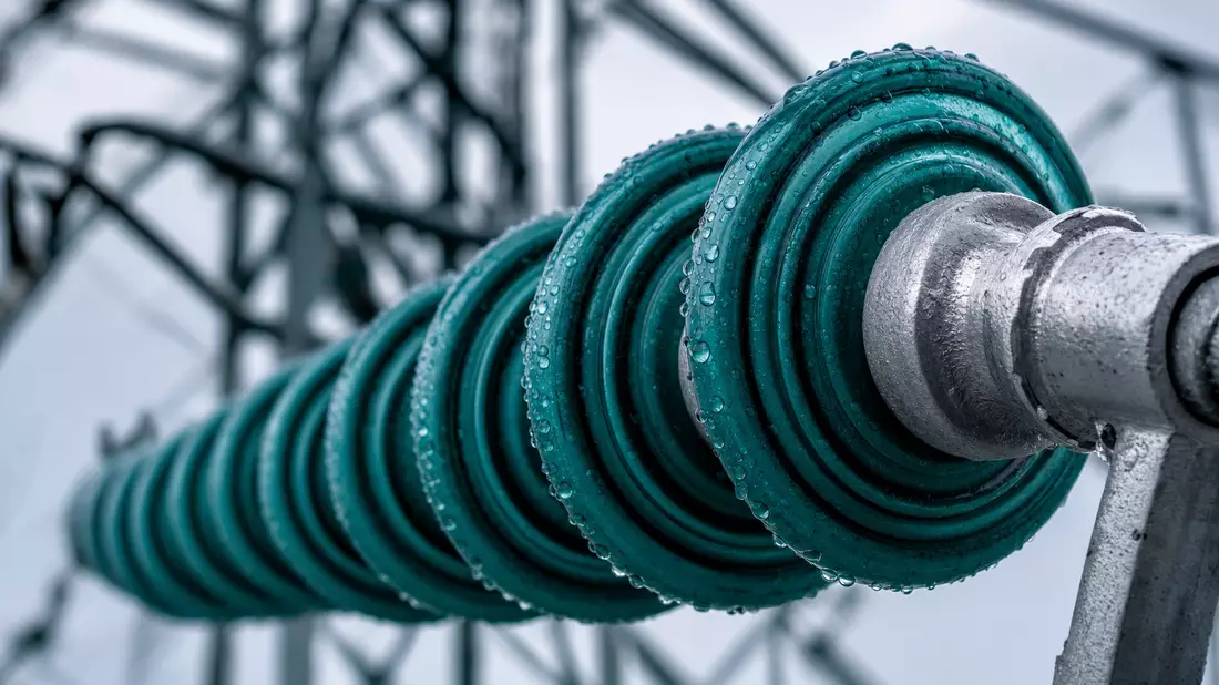 Ameren Corp. US0236081024 – macro photograph of glazed ceramic high-voltage insulator with rain droplets