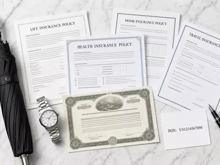 American International Group US0268747849 overhead flatlay insurance policy documents umbrella watch stock certificate - Foto: THN