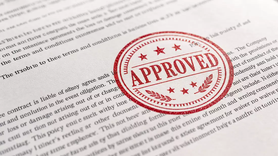American International Group US0268747849 macro close-up insurance contract with red approval stamp