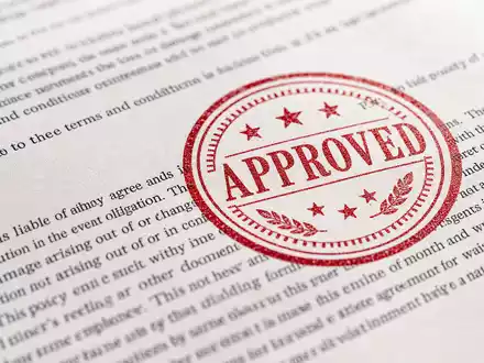 American International Group US0268747849 macro insurance contract red approval stamp visible paper texture - Foto: THN
