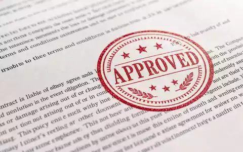 American International Group US0268747849 macro insurance contract red approval stamp visible paper texture - Foto: THN