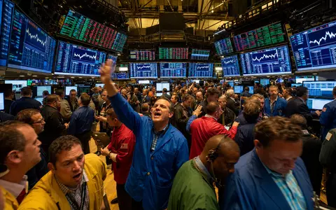American International Group US0268747849 NYSE trading floor colorful traders insurance sector stock charts - Foto: THN