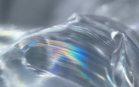 Amcor plc JE00BJ1F6598 extreme macro of iridescent rainbow interference patterns on transparent polymer film surface - Foto: THN