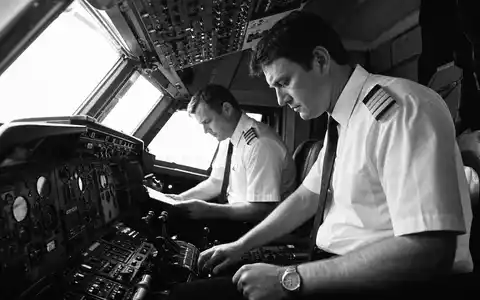 American Airlines Group Aktie US02376R1023 Schwarz-Weiß-Reportage zwei Piloten Cockpit-Vorflugkontrolle an komplexem Instrumentenpanel - Foto: THN
