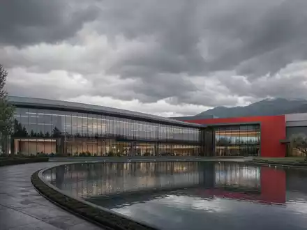 Ferrari N.V. NL0011585146: Architektur-Render des modernen Luxussportwagen-Hauptquartiers mit Glasfassade, Teich und Bergen - Foto: THN