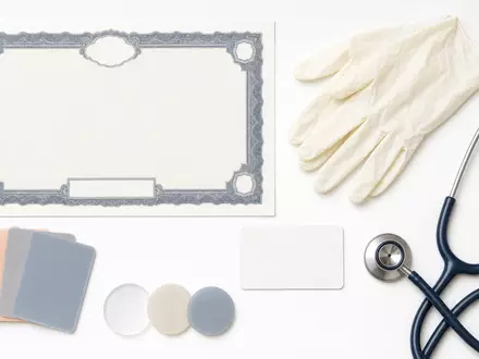 Coloplast A/S (DK0060448595) und die Branche inspirieren dieses Flatlay mit Aktienzertifikat, ISIN-Karte und medizinischen Utensilien - Foto: THN