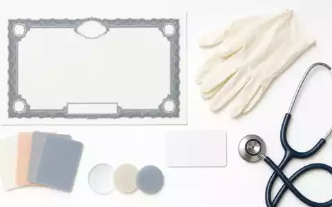 Coloplast A/S (DK0060448595) und die Branche inspirieren dieses Flatlay mit Aktienzertifikat, ISIN-Karte und medizinischen Utensilien - Foto: THN