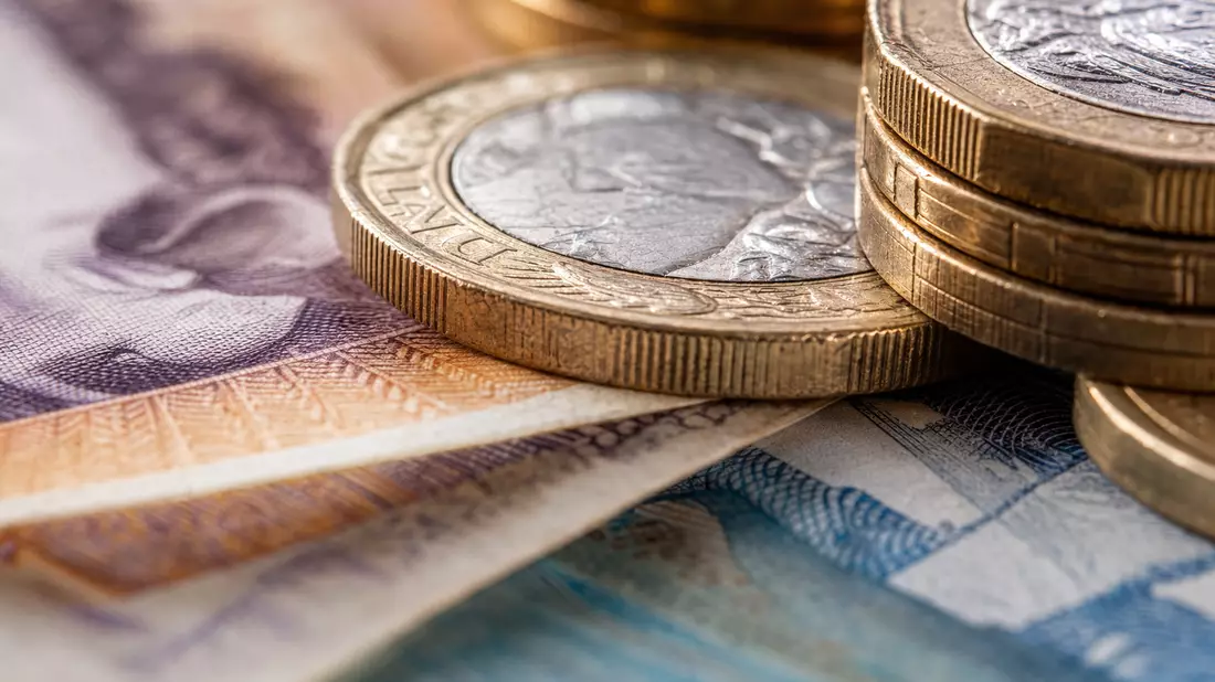Makroaufnahme von britischen Pfund-Münzen und Banknoten in scharfer Nahaufnahme