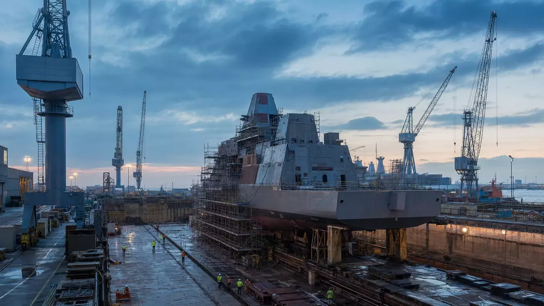Fotorealistische Werftszene mit Fregattenrumpf im Trockendock bei Abenddämmerung