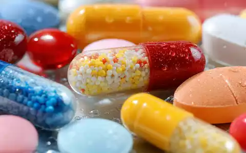 Makroaufnahme veranschaulicht Molina Healthcare US60855R1005 durch detailreiche bunte Tabletten und glänzende Kapseln mit Wassertropfen - Foto: THN