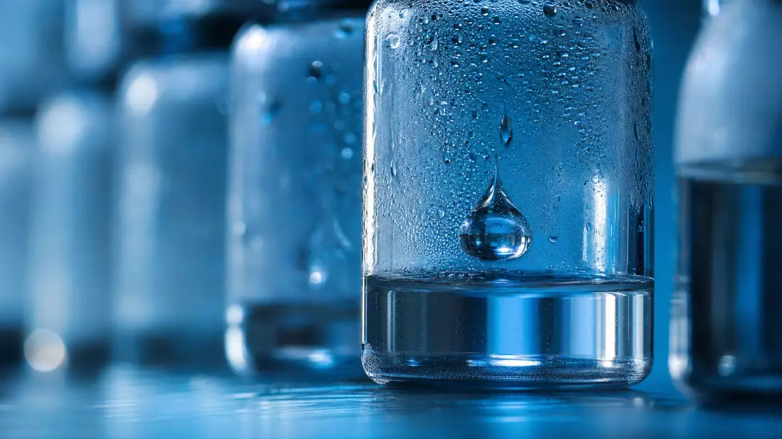 Extreme Makroaufnahme eines Wassertropfens in beschlagenem Laborglas mit blauem Licht