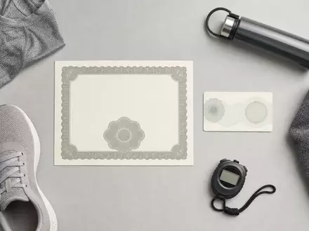 PUMA SE (ISIN DE0006969603) zeigt Flatlay mit Aktienzertifikat, ISIN-Karte und unmarkierten Sportartikeln - Foto: THN