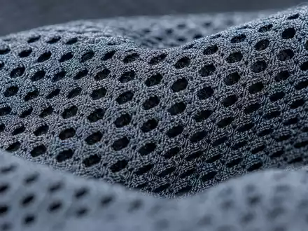 PUMA SE (ISIN DE0006969603) zeigt Makroaufnahme eines technischen Sportgewebes mit feiner Netzstruktur ohne Markenzeichen - Foto: THN
