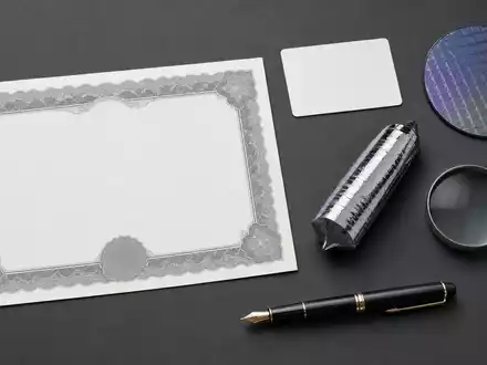PVA TePla AG (DE0007461006) zeigt Flatlay mit Aktienzertifikat, ISIN-Karte, Wafer und Kristall-Ingot - Foto: THN