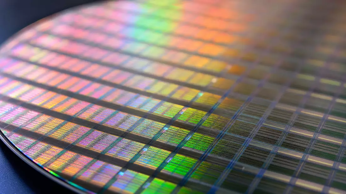 Makroaufnahme eines glänzenden Siliziumwafers mit schillernden Reflexionen