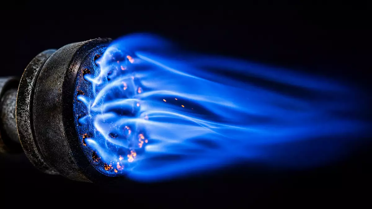 Extreme Makroaufnahme einer blau leuchtenden Erdgasflamme an einem Metallbrenner