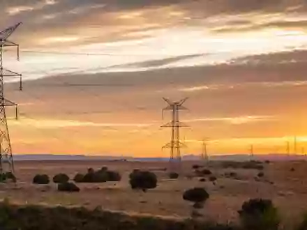 Fotorealistische Hochspannungsmasten in Kastilien symbolisieren Redeia (Red Eléctrica), ISIN ES0173093024, Stromnetzbetreiber bei Sonnenuntergang - Foto: THN
