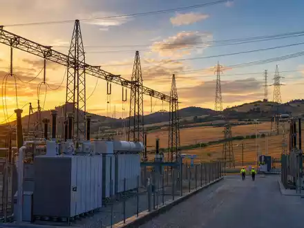 Terna - Rete Elettrica Nazionale IT0003242622 zeigt Hochspannungs-Umspannwerk mit Strommasten in Hügellandschaft bei Sonnenuntergang - Foto: THN