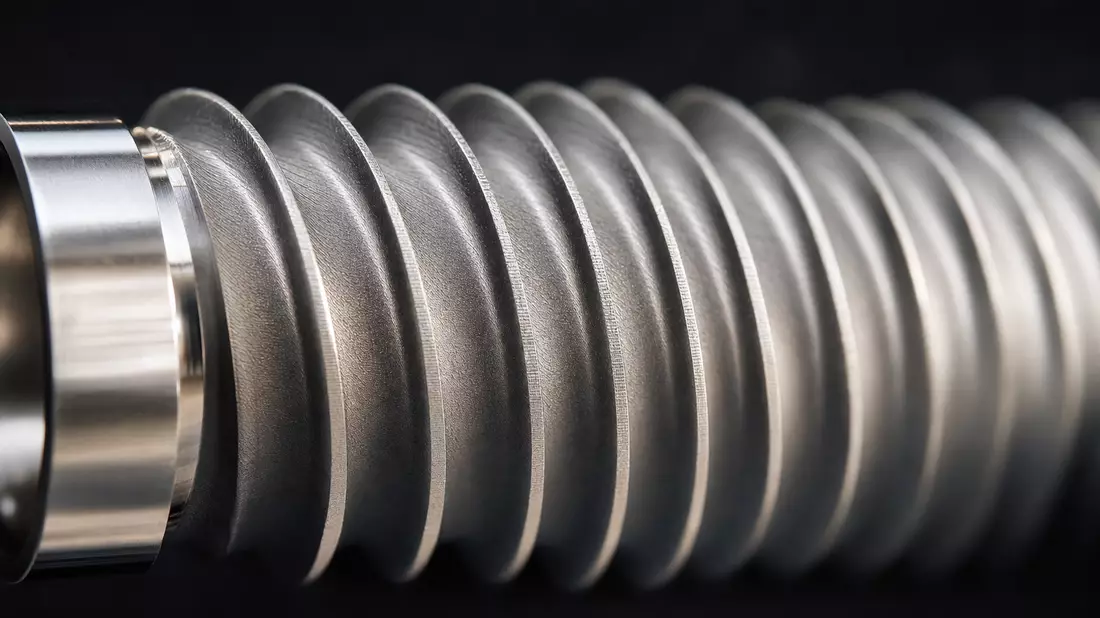 Makroaufnahme des feinen Schraubgewindes eines polierten Titan-Dentalimplantats