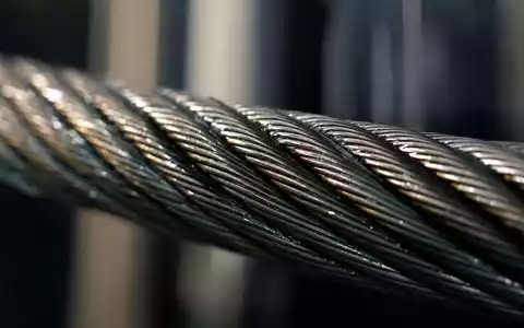 Schindler Holding AG (ISIN CH0024638196) zeigt Makroaufnahme eines geflochtenen Stahlseils mit metallischem Glanz und Detailtextur - Foto: THN