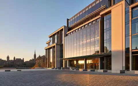 NatWest Group plc Hauptsitz als modernes Glasgebäude in Edinburgh bei goldenem Abendlicht, ISIN GB00BM8PJ831 - Foto: THN