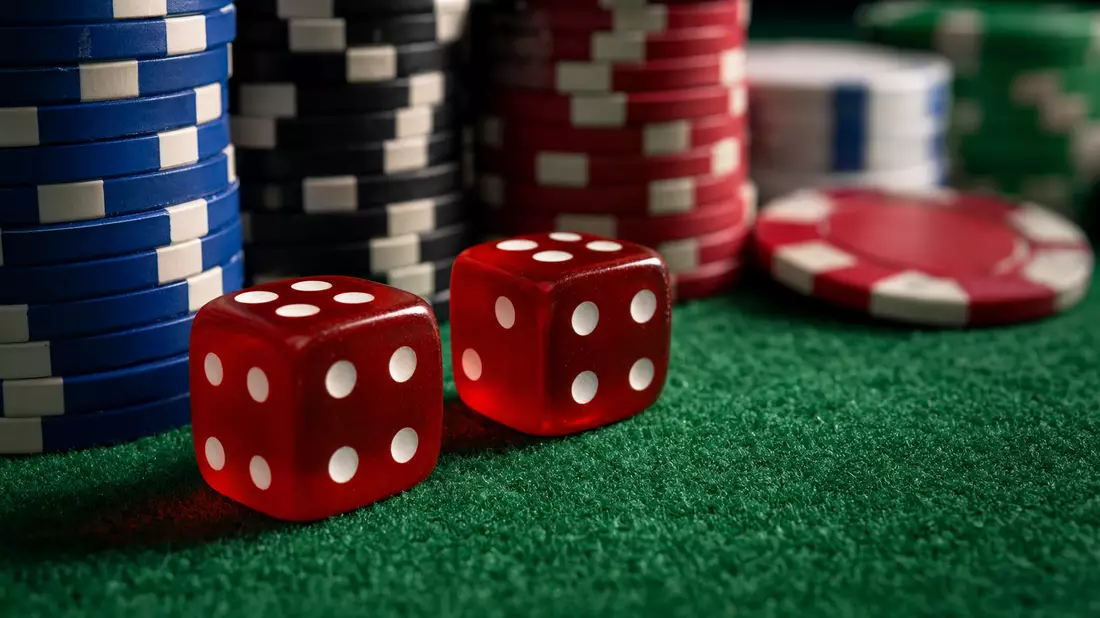 Makrofoto von Spielwürfeln und Pokerchips, Flutter Entertainment plc IE00BWT6H894