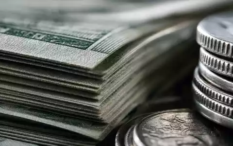 Makroaufnahme von Banknoten und Münzen visualisiert Standard Chartered PLC, ISIN GB0004082847, Finanzdienstleistungen im Detail - Foto: THN