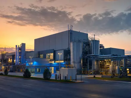 Fotorealistische Pharma-Produktionsanlage bei Dämmerung symbolisiert Pfizer Inc. mit ISIN US7170811035 im Biotech-Sektor - Foto: THN