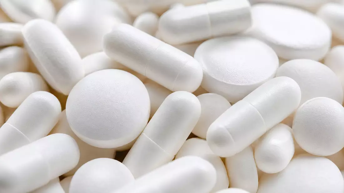 Extreme Nahaufnahme unbeschrifteter weißer Tabletten und Kapseln, Symbolbild für Pfizer Inc