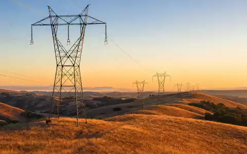 Fotorealistische Hochspannungsleitung in kalifornischen Hügeln symbolisiert PG&E Corporation, Aktie ISIN US69331C1080, Sonnenuntergang - Foto: THN