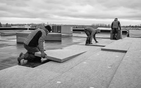 Schwarzweiß-Reportagefoto zeigt Dachdämmung mit Steinwolle, symbolisiert Kerngeschäft von Rockwool A/S, ISIN DK0010219153 - Foto: THN