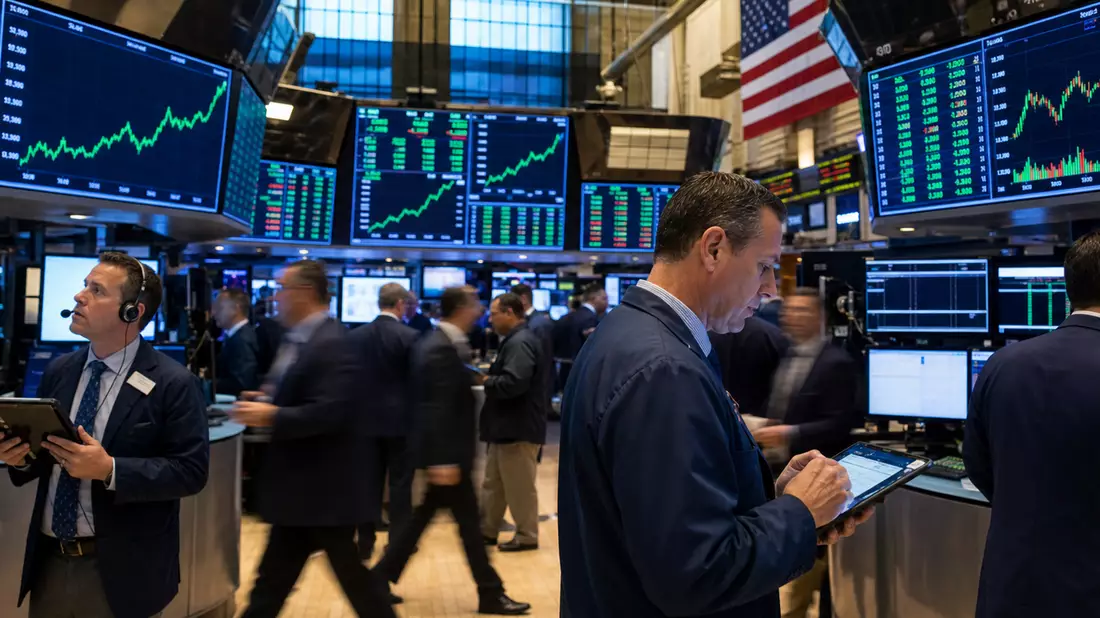 Editorial-Aufnahme vom Trading-Floor der Börse mit Kursdiagrammen auf Bildschirmen