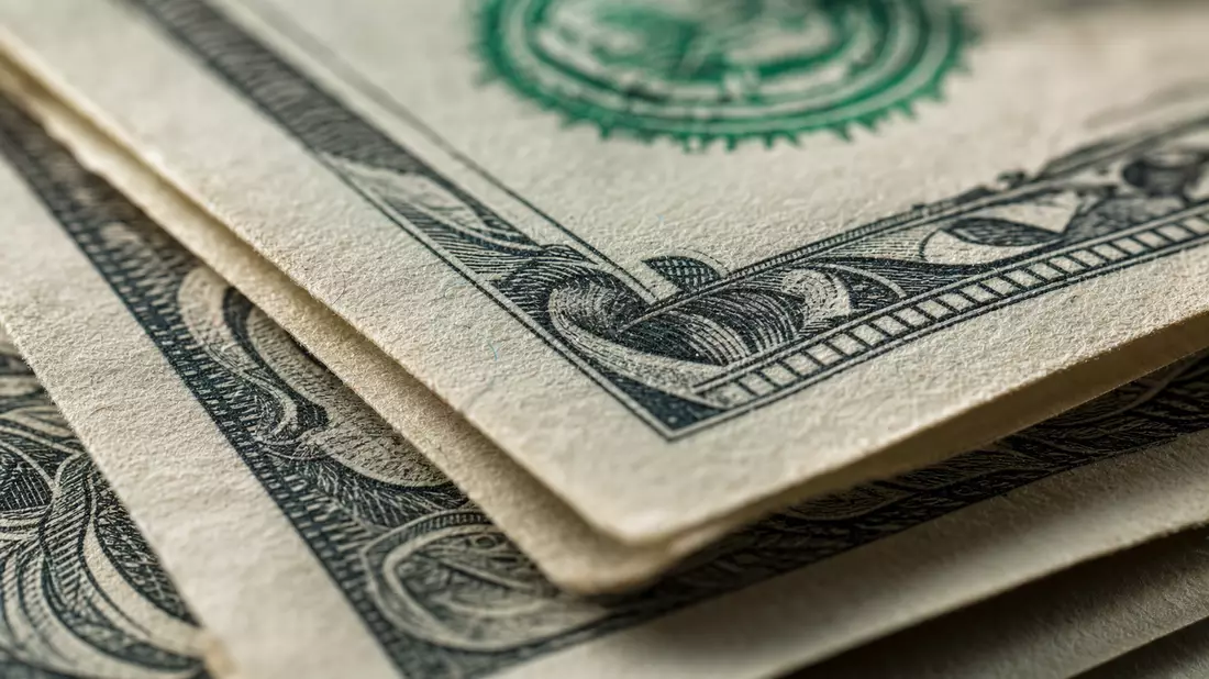 Makroaufnahme gestapelter Dollarnoten mit feinen Papier- und Druckdetails