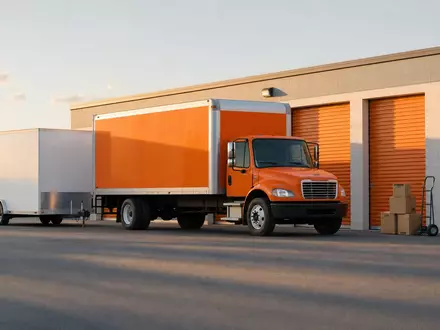 Fotorealistisches Bild von U-Haul Holding Co. zeigt Umzug-LKW und Anhänger vor Lagerhalle, ISIN US02744A1097 - Foto: THN