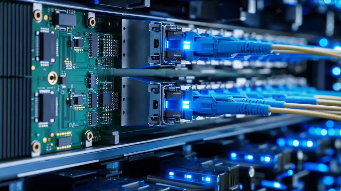 Makrofoto einer Serverplatine mit leuchtend blauen Glasfaserkabeln und Steckverbindern