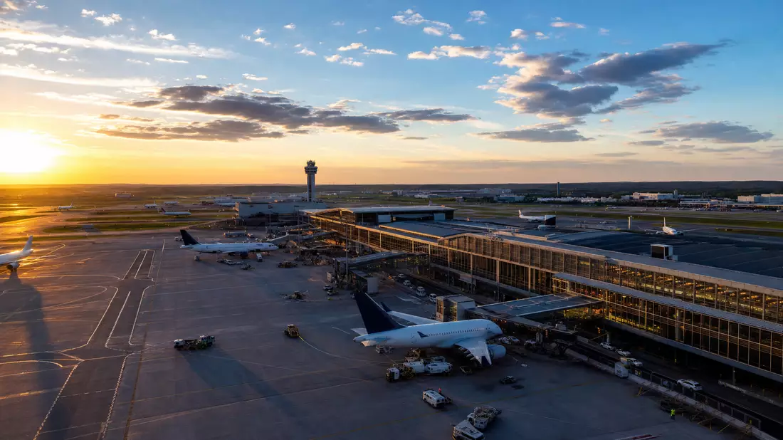 Fotorealistisches Luftbild eines internationalen Flughafens mit Terminals und Rollfeld bei Sonnenuntergang