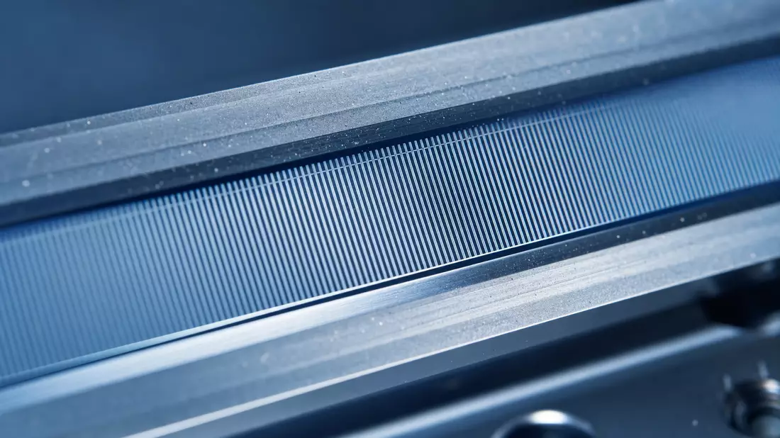 Makroaufnahme einer optischen Encoder-Skala mit feinen metallischen Gitterlinien