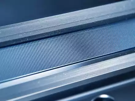 Renishaw plc (GB0007365546) entwickelt optische Encoder, hier als Makroaufnahme feiner Präzisionsgitterlinien in kühlem Licht - Foto: THN