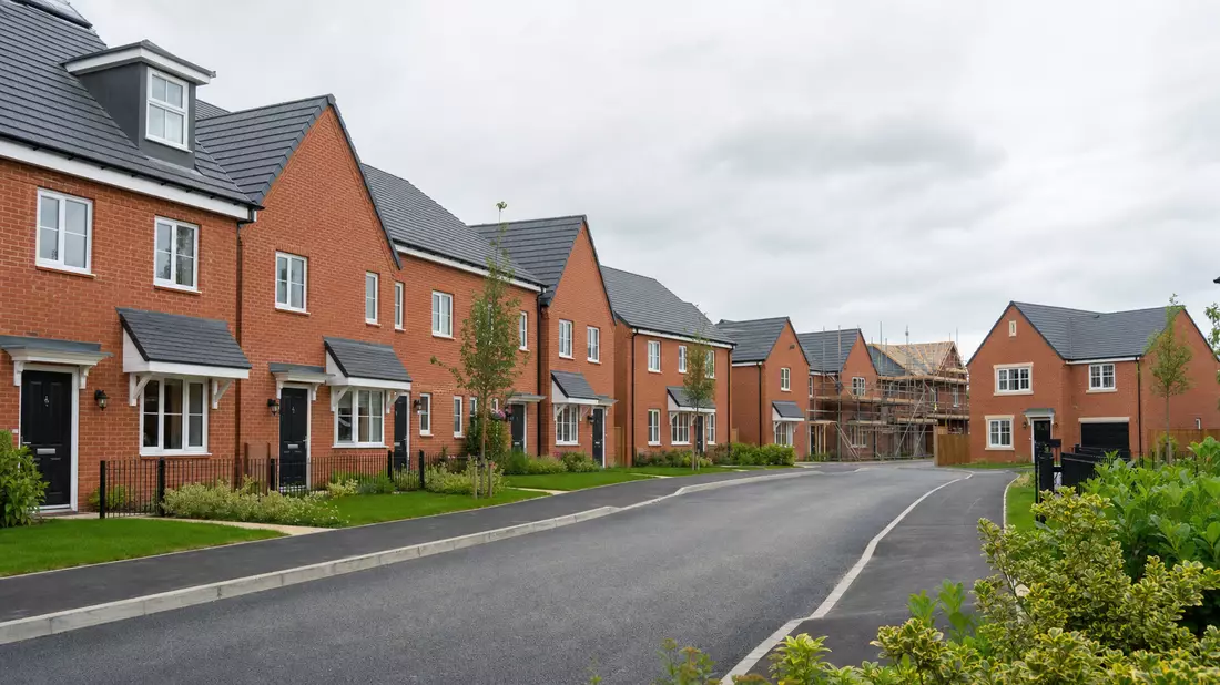 Neue Wohnsiedlung mit Backsteinhäusern und frisch gepflasterten Straßen in England