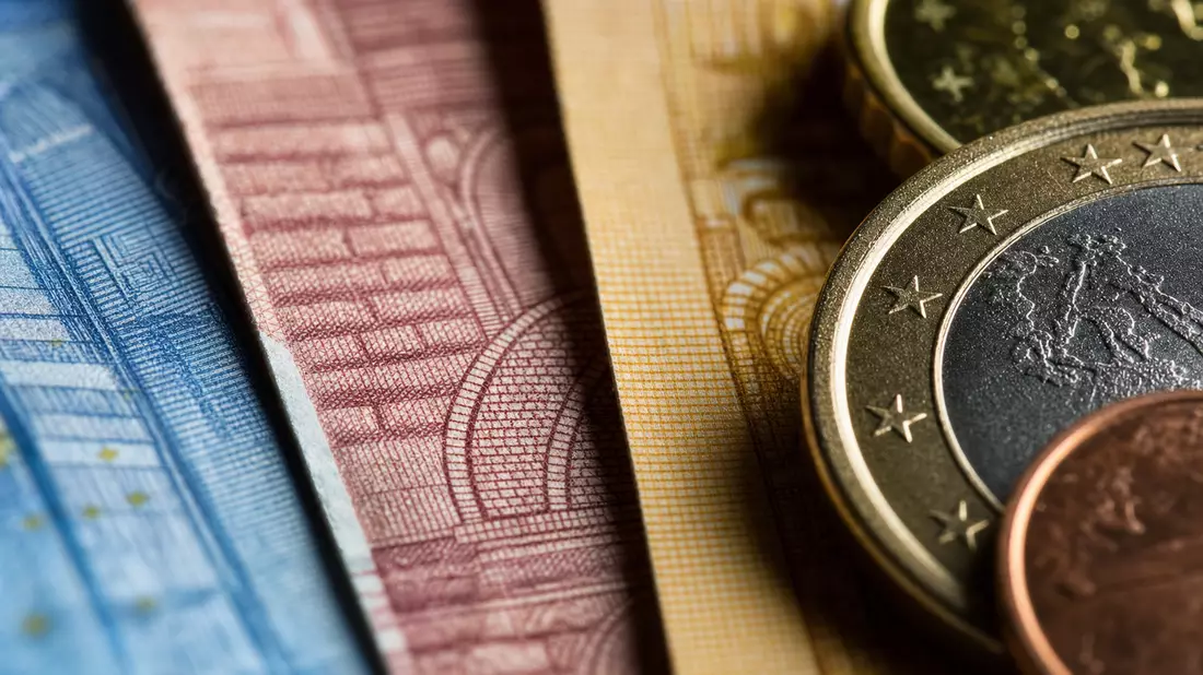 Makroaufnahme von Euro-Banknoten und Münzen mit feiner Druckstruktur