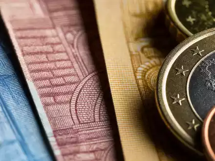 Makroaufnahme von Banknoten und Münzen symbolisiert Mediobanca S.p.A. mit ISIN IT0000062957 im Finanzgeschäft Italiens - Foto: THN
