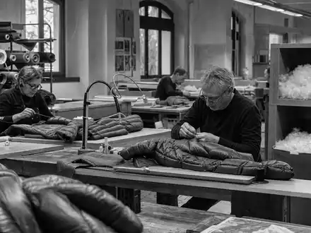 Moncler S.p.A. (IT0004965148) dokumentiert in Schwarzweiß ein italienisches Nähatelier für hochwertige Daunenjacken - Foto: THN