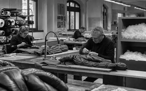 Moncler S.p.A. (IT0004965148) dokumentiert in Schwarzweiß ein italienisches Nähatelier für hochwertige Daunenjacken - Foto: THN