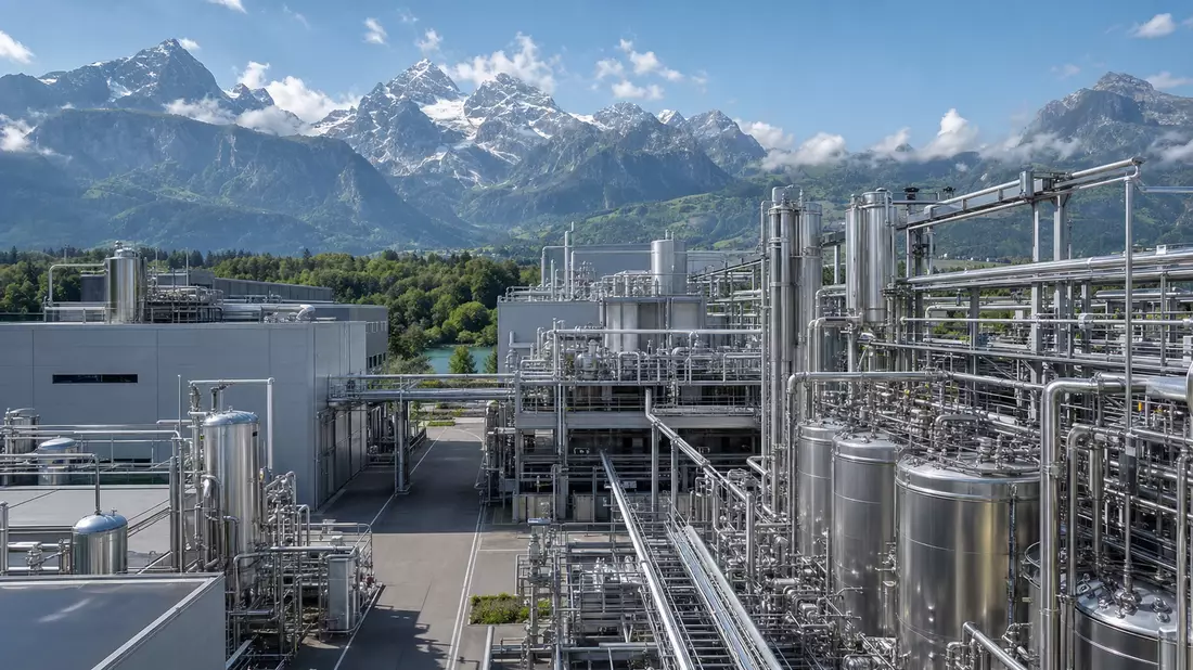 Fotorealistische Peptid-Produktionsanlage mit Alpenpanorama im Hintergrund